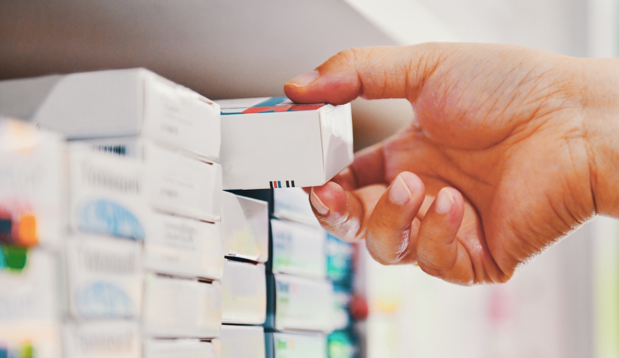 Large image of a pharmacist grabbing medication from the shelf