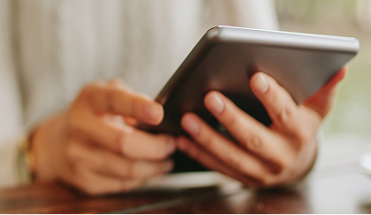 Two hands holding an iPad